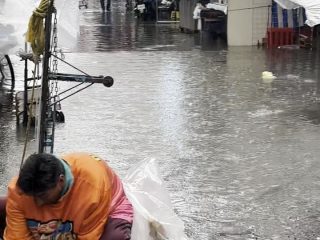 Hombre lava su ropa con agua de lluvia en calles de CDMX